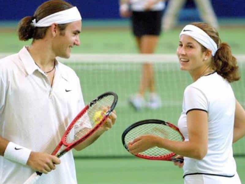 Mirka Federer playing tennis with husband, Roger.